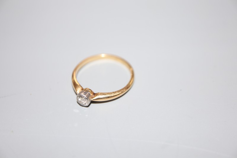 An 18ct and millegrain set solitaire diamond ring, size N, gross 2.5 grams.